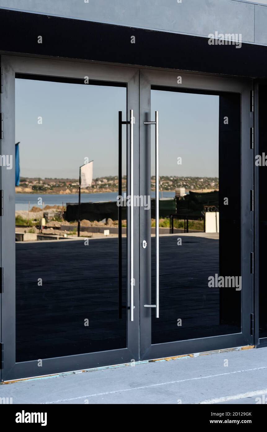 Black glass front doors with metal handles. Entrance to the building of