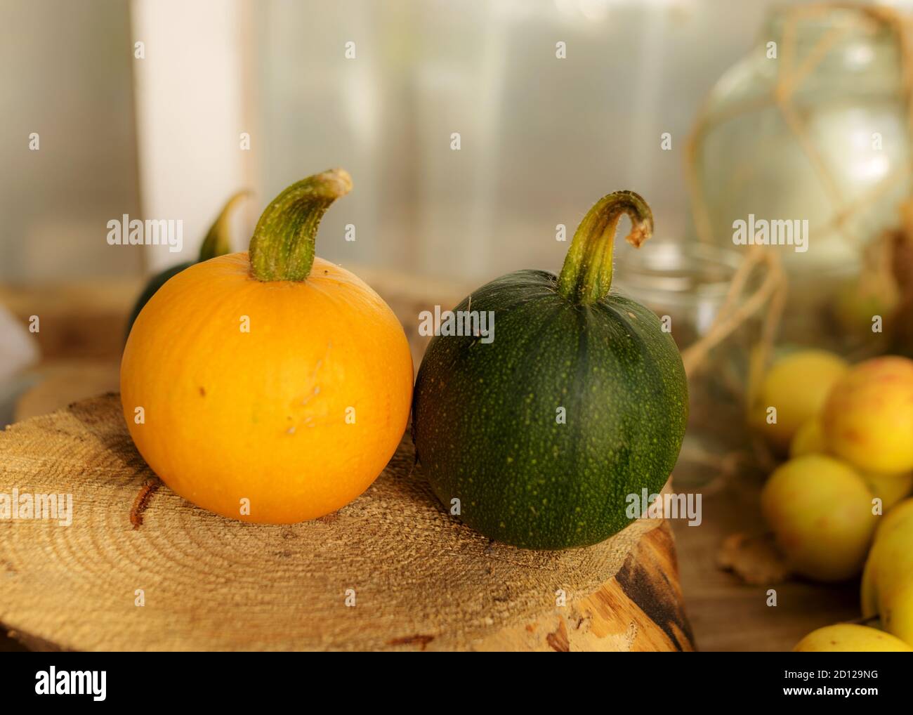 composition of small pumpkins and apples, wooden disc base, Halloween time, autumn Stock Photo