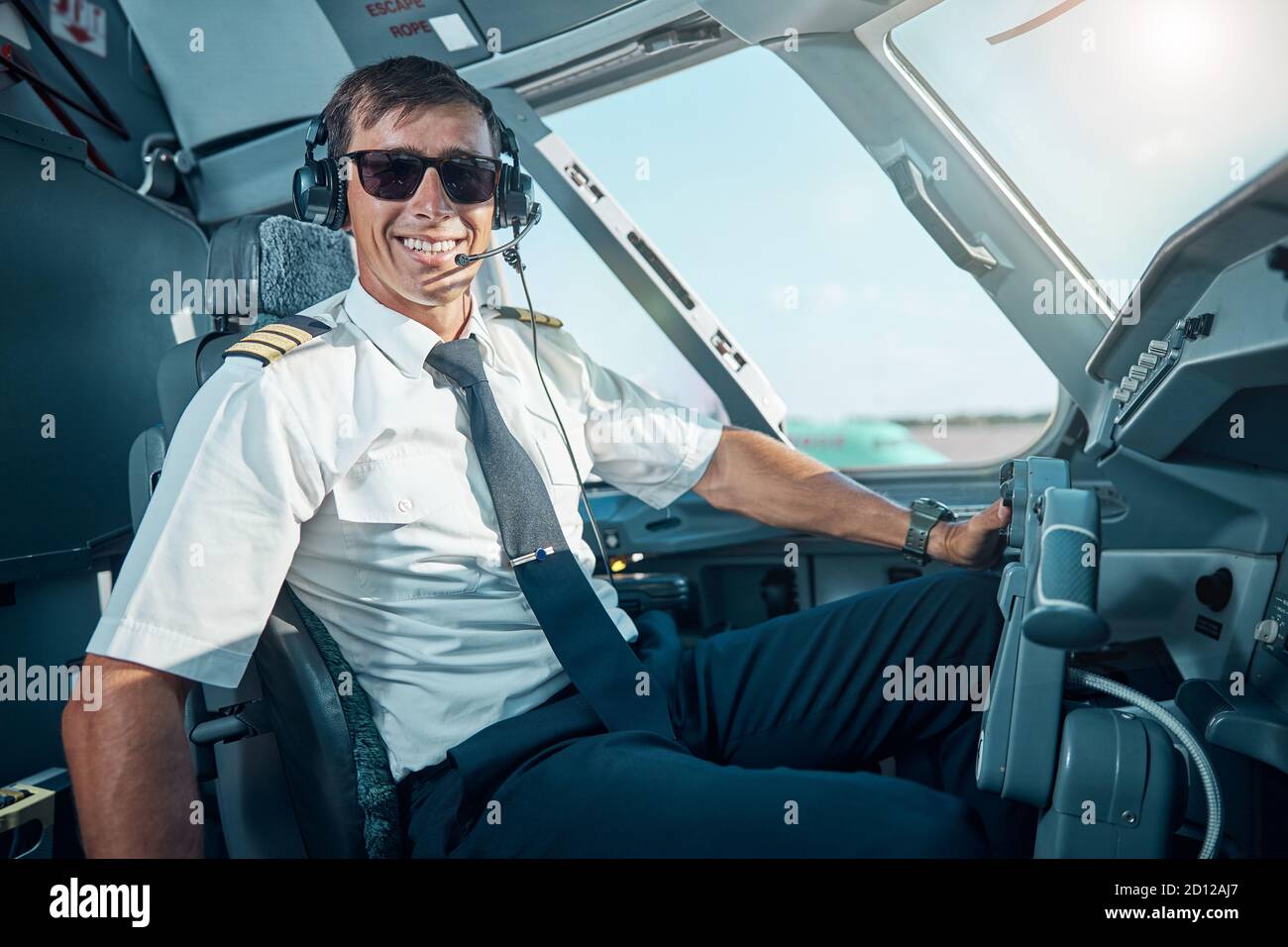 Smiling handsome pilot enjoying his work in aircraft Stock Photo Alamy
