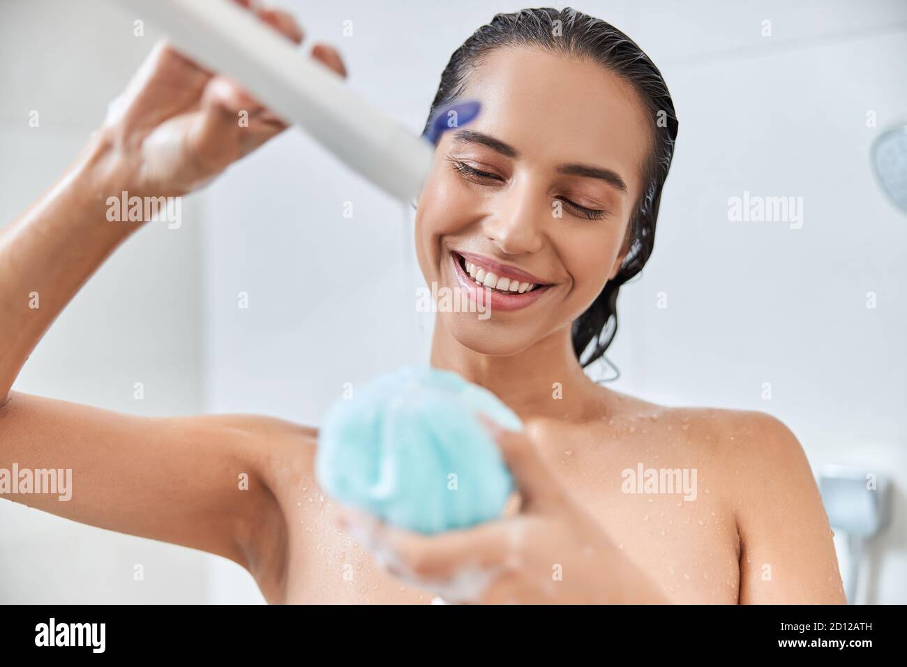 Charming young woman pouring shower gel on bath loofah Stock Photo Alamy