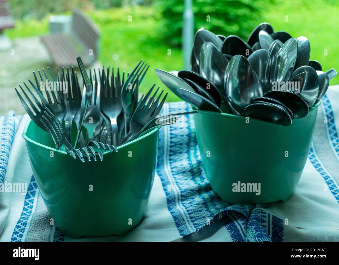 school kitchen canteen, metal spoons and knives in green plastic