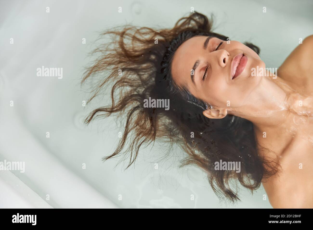 Beautiful young woman lying in water in bathtub Stock Photo - Alamy