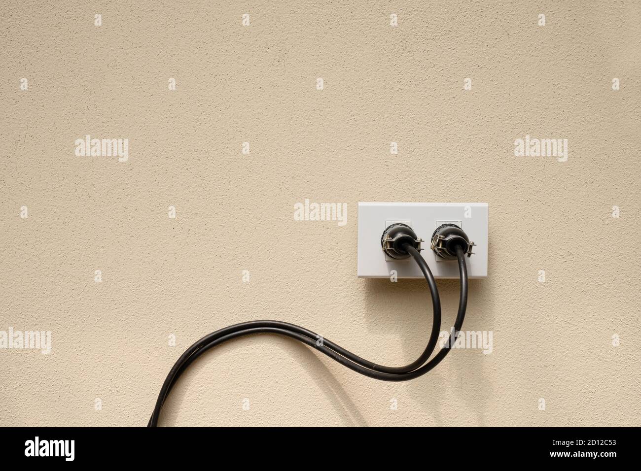 Electric wire plug Receptacle on the concrete wall background Stock Photo