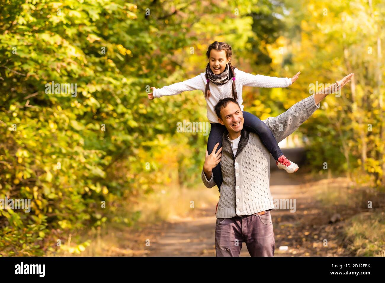 Happy family father and child daughter on a walk in the autumn leaf ...