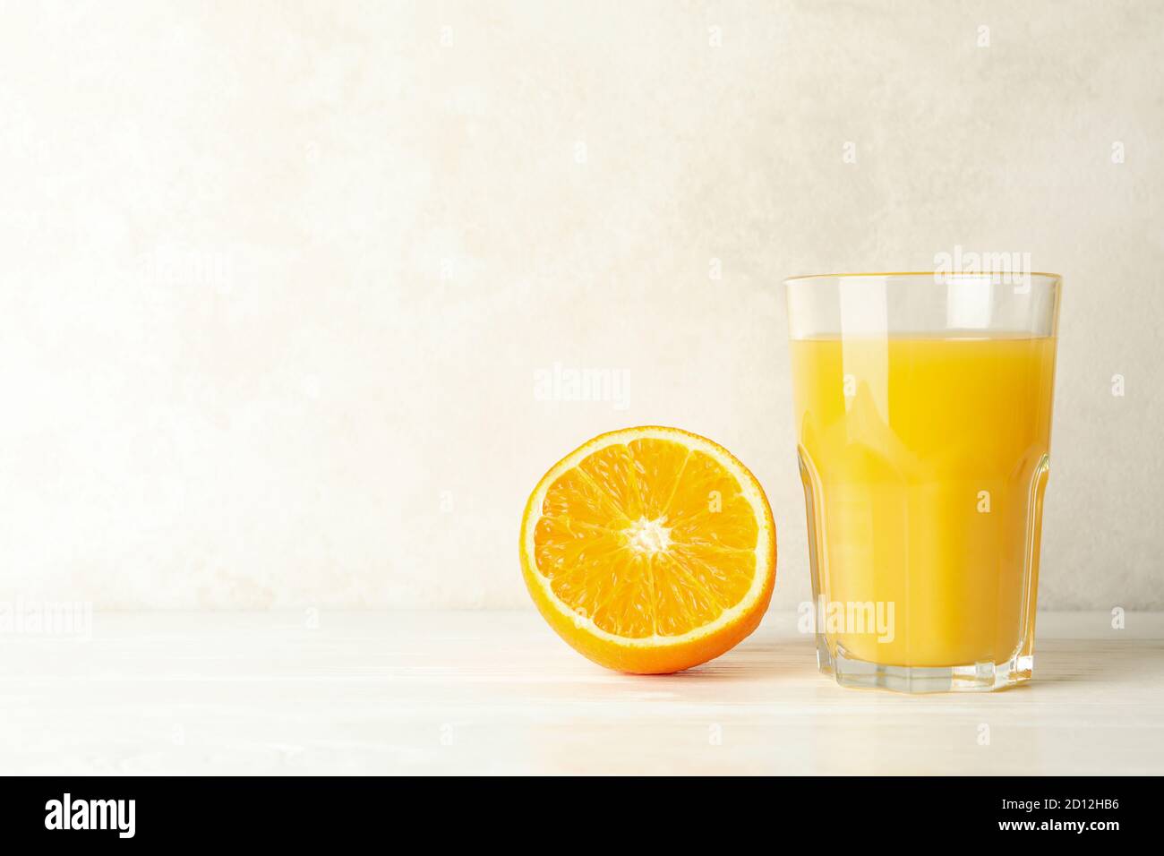 Glass of fresh orange juice on white wooden table Stock Photo