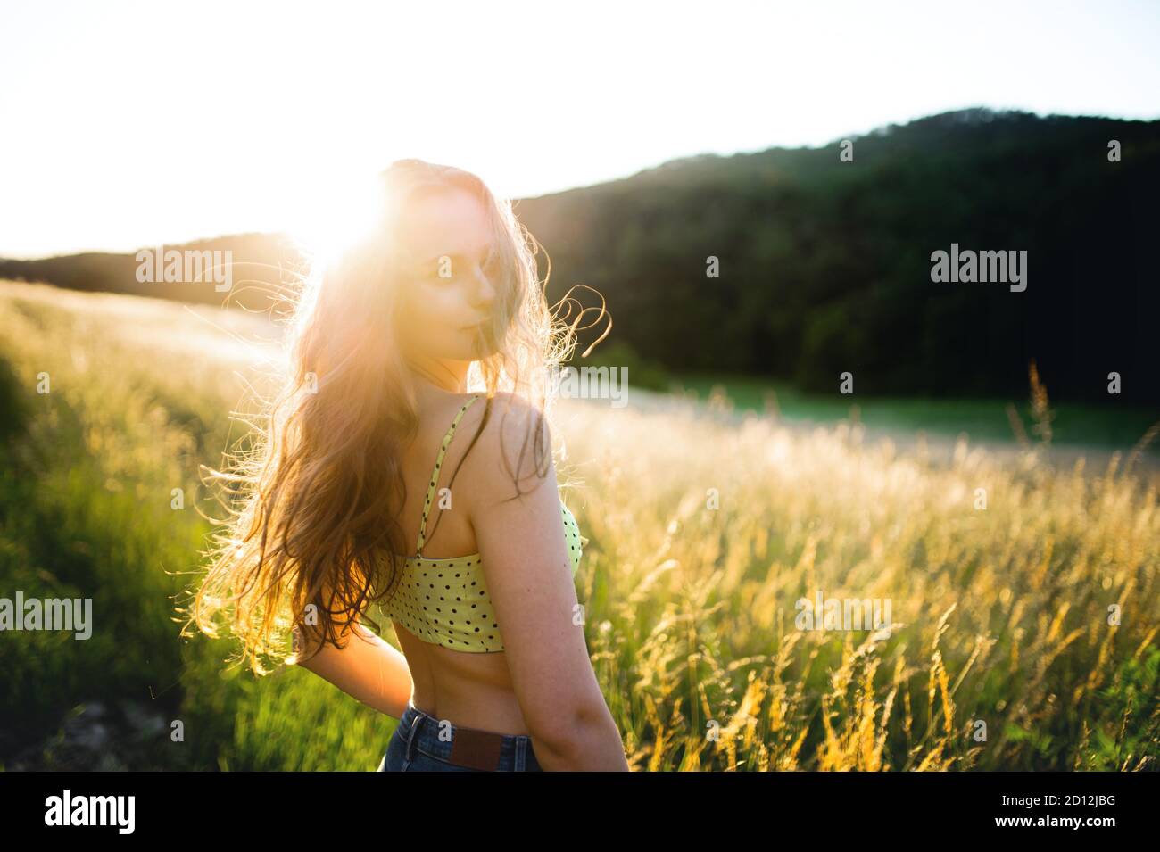Portrait of young teenager girl outdoors in nature at sunset. Stock Photo
