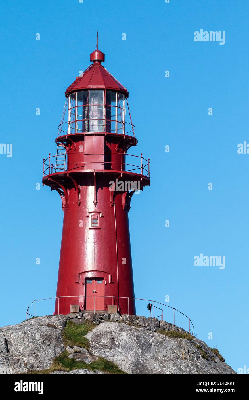 The Ona archipelago consists of the two islands Ona and Husøya. 1867 the famous, red,14,7 metres cast iron lighthouse was built on top of Onakalven. Stock Photo