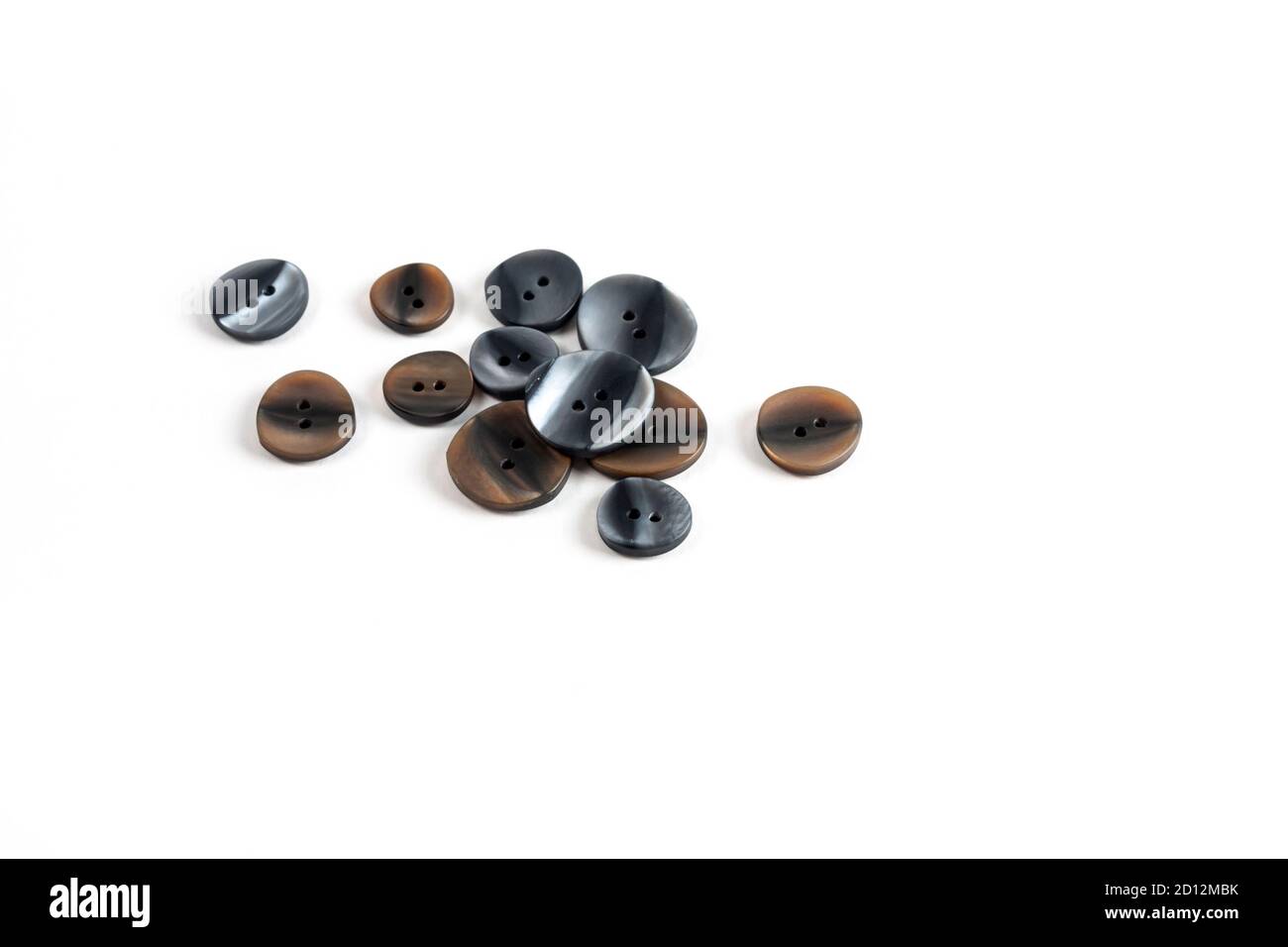 pile, allsorts of brown old gray, beige and brown buttons on a white background. image for sewing and tailor store. space for text Stock Photo