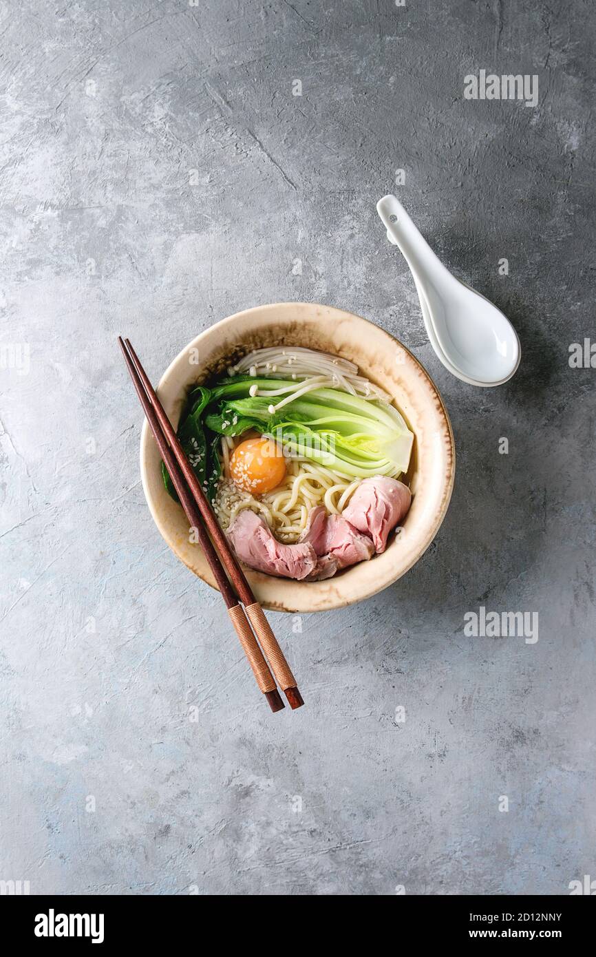 Asian dish udon noodles with egg yolk, sesame, mushrooms, boc choy