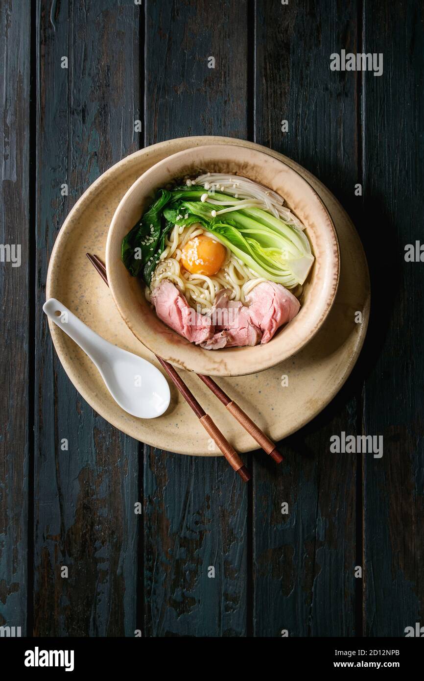 Asian dish udon noodles with egg yolk, sesame, mushrooms, boc choy