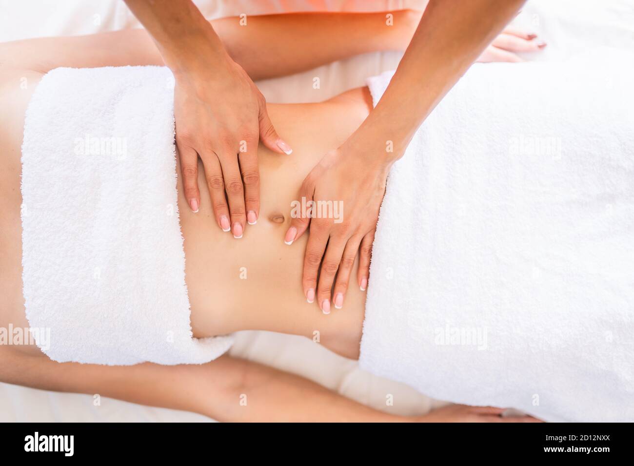 Woman have belly massage in light procedure room. Anti-cellulite massage, diastasis. Stock Photo