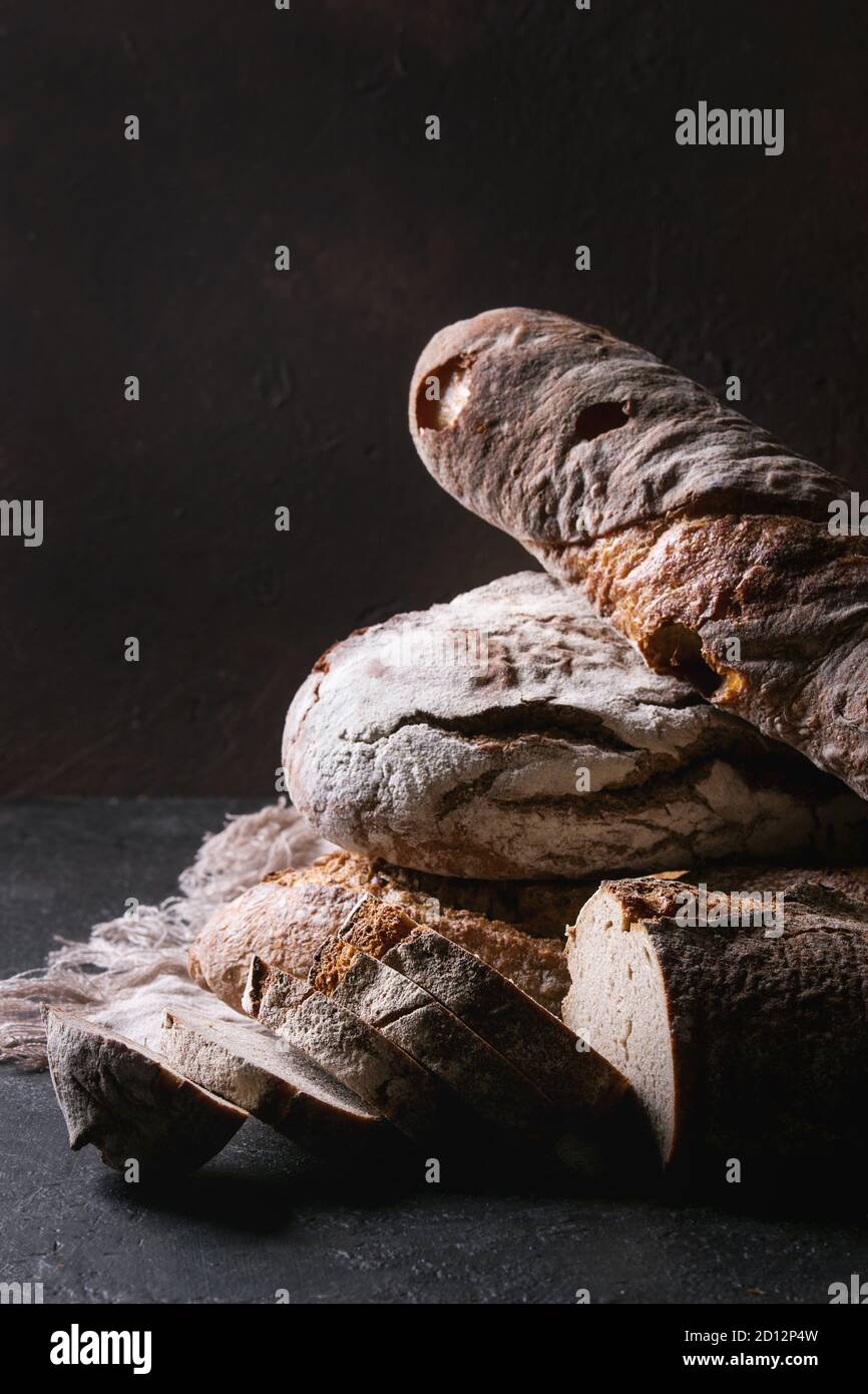 Variety of loafs fresh baked artisan rye and whole grain bread on linen ...