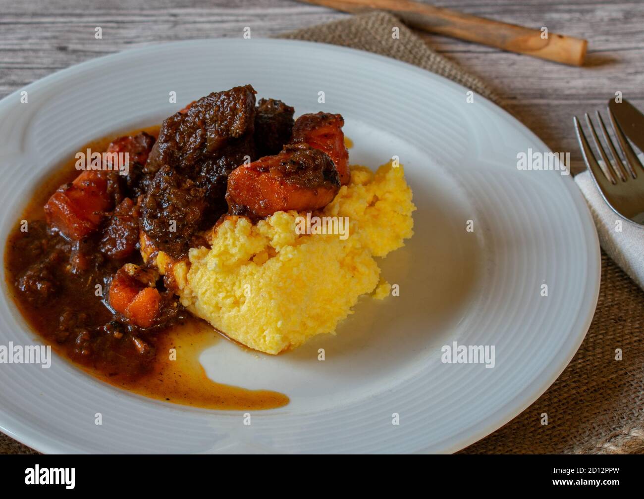 italian braised beef stew with creamy polenta Stock Photo