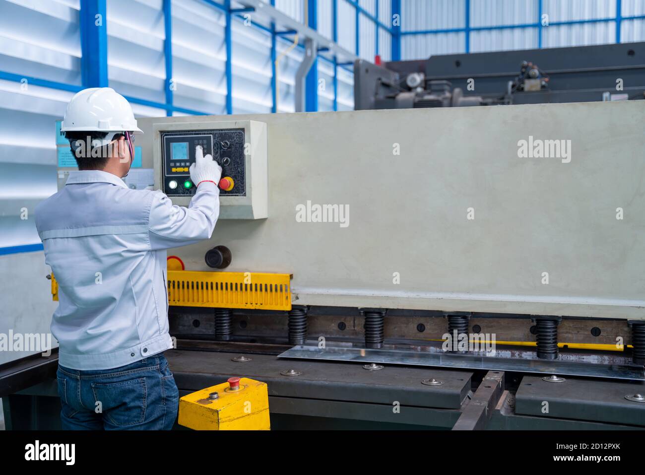 Asian worker wearing a safety suit and setting Hydraulic Press Break ...