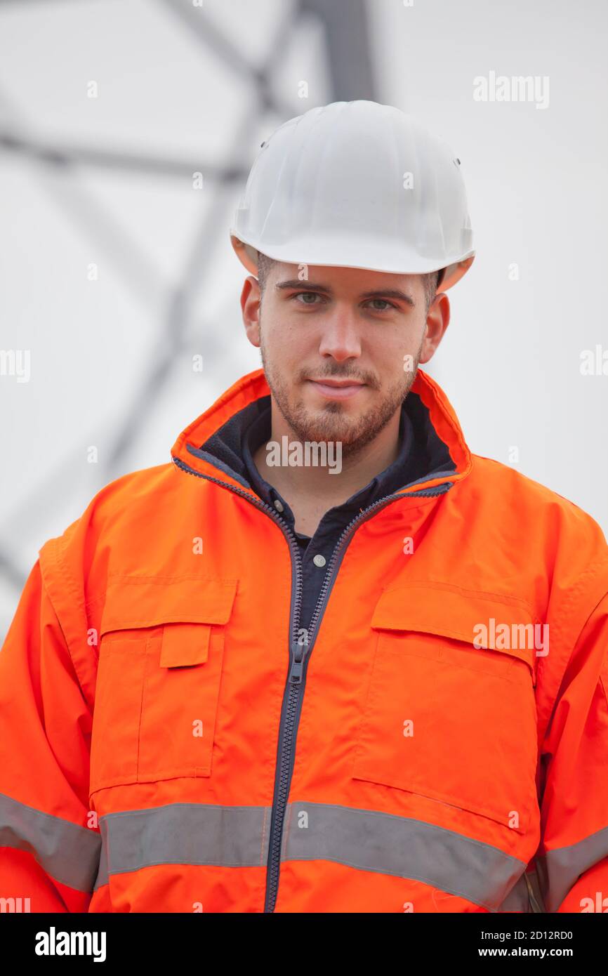 Young confident engineer or architect looking at camera on a construction site - selective focus Stock Photo