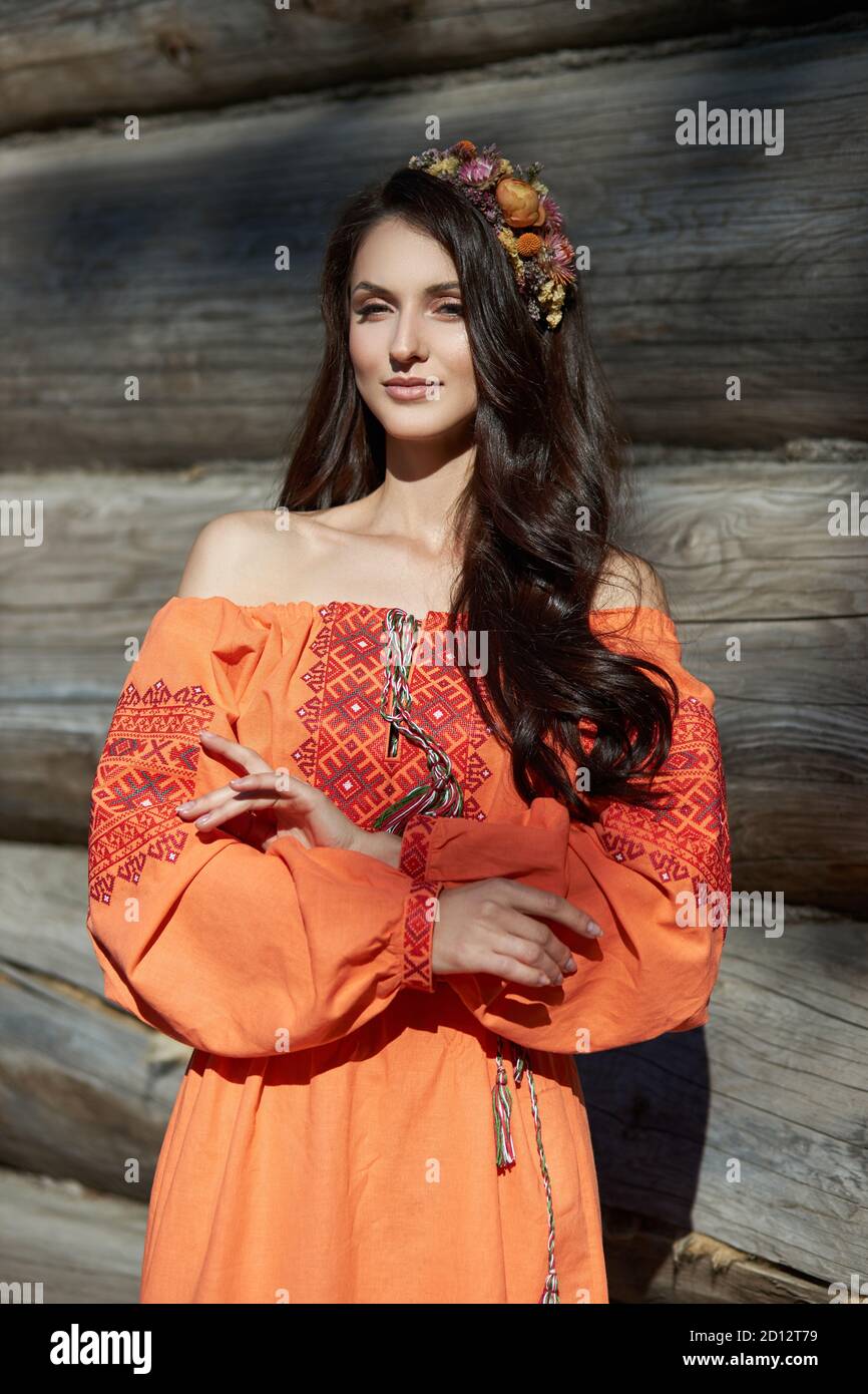 https://c8.alamy.com/comp/2D12T79/beautiful-slavic-woman-in-an-orange-ethnic-dress-and-a-wreath-of-flowers-on-her-head-beautiful-natural-makeup-portrait-of-a-russian-girl-2D12T79.jpg