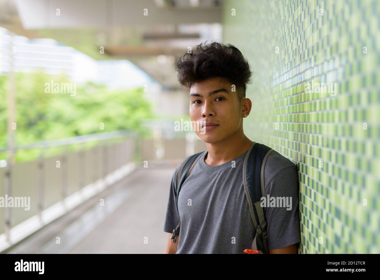 Young Asian tourist man as backpacker at the footbridge Stock Photo