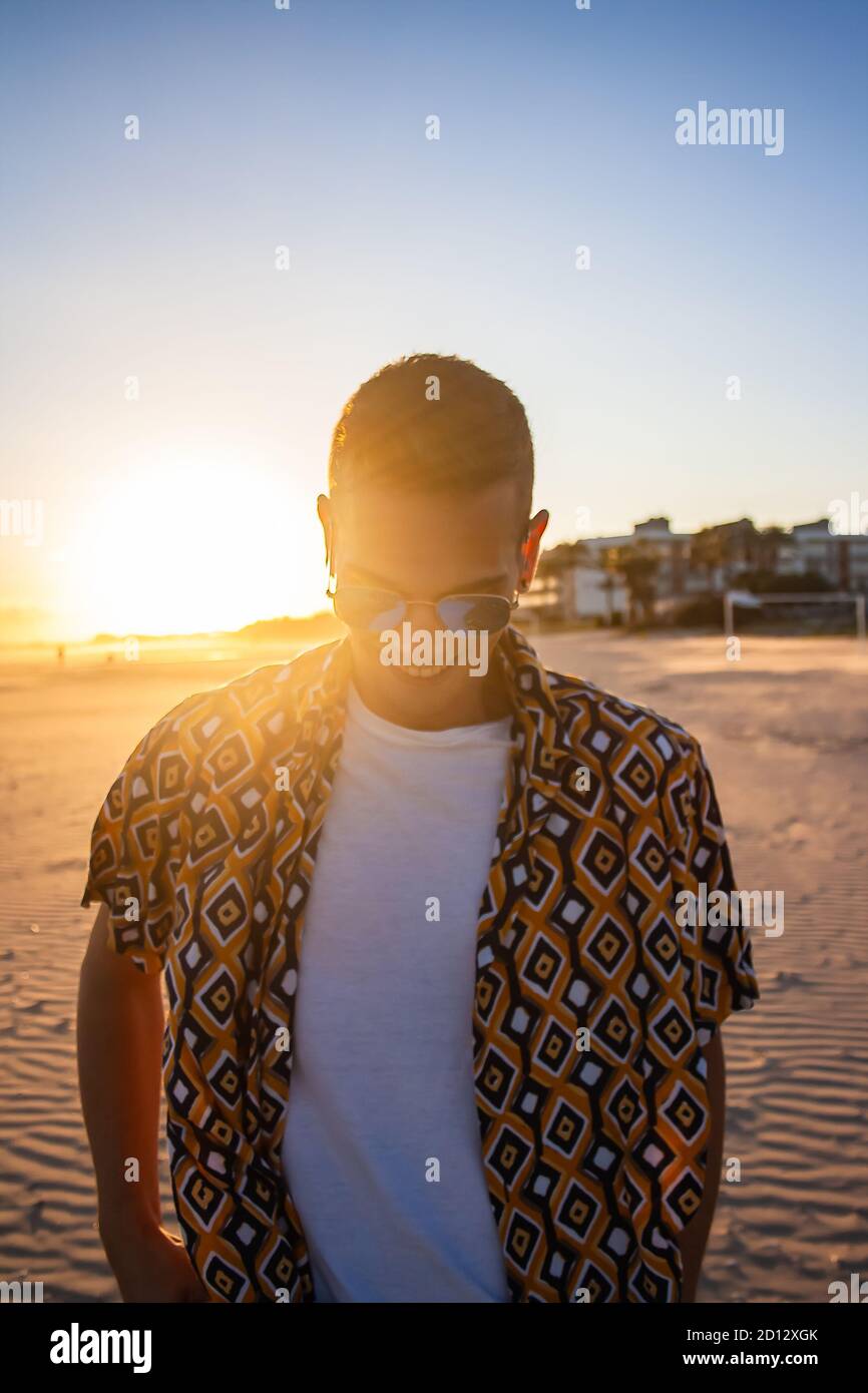 Young man sunset portrait. Sunset in background. Vertical view. Stock Photo