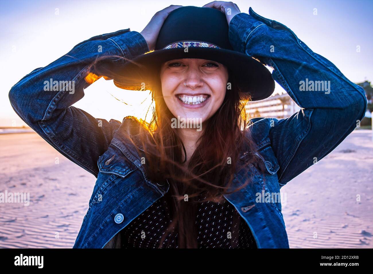 Young bohemian woman portrait on a walk at beach sunset. Horizontal view. Medium shot. Stock Photo