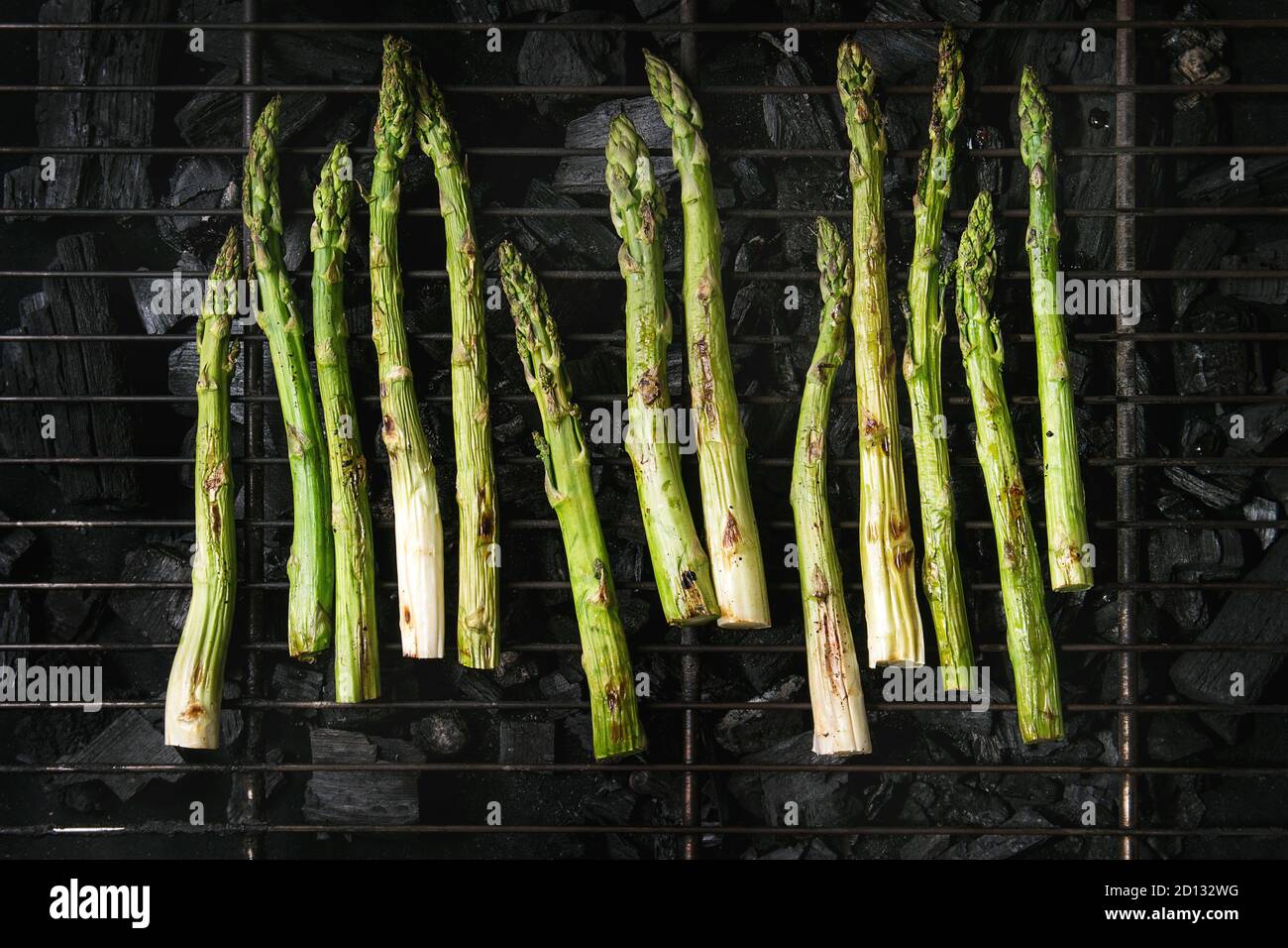 Grilled vegetables green asparagus on bbq grill rack over charcoal. Top