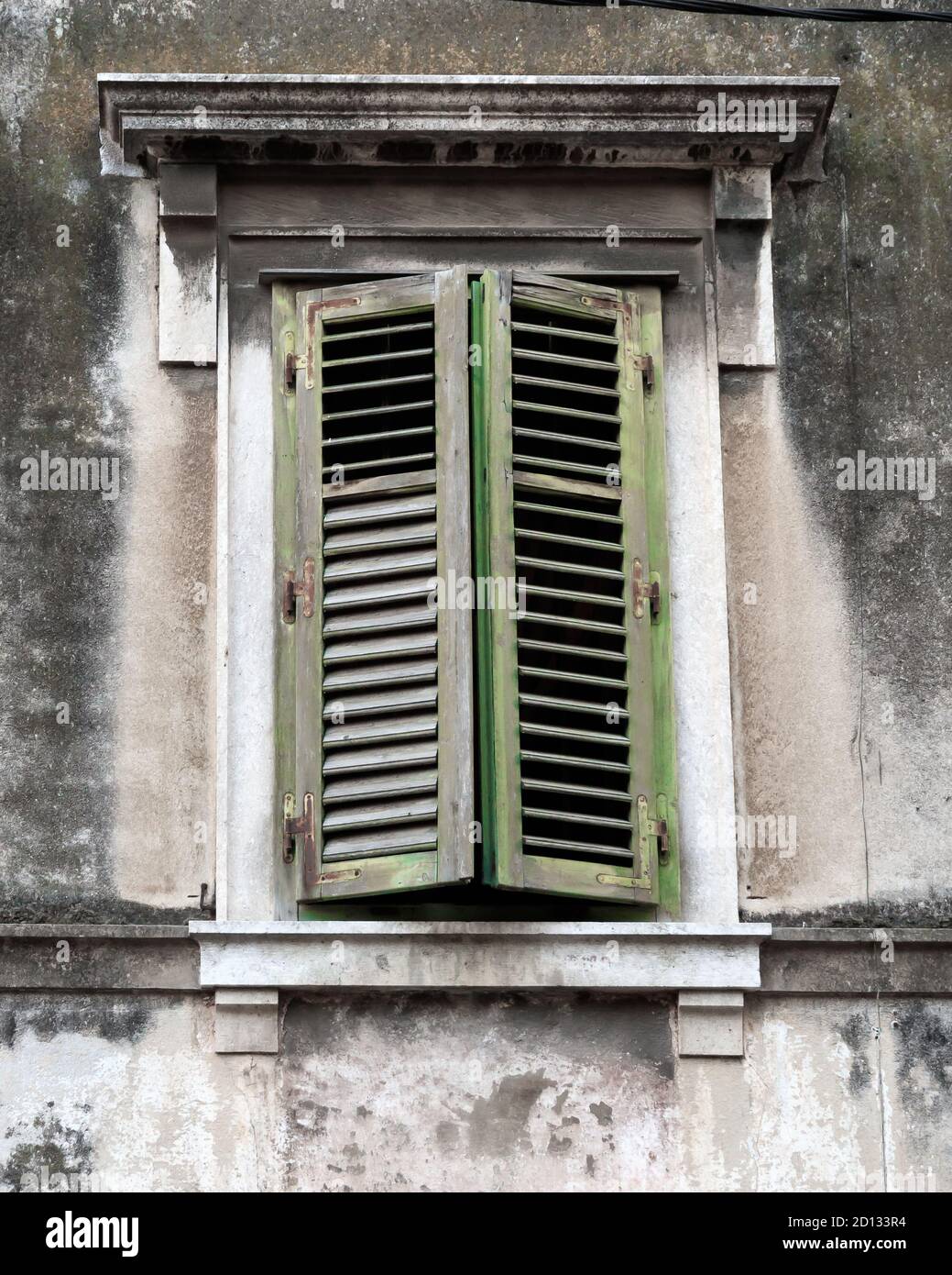 SPLIT, CROATIA - 2017 AUGUST 15. Old brick house with windows protected by closed green wooden shutters. Stock Photo