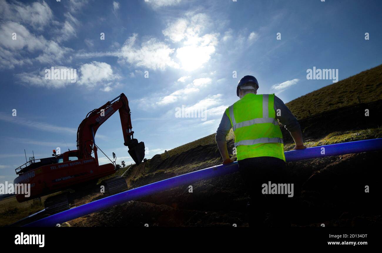 Construction worker on site, laying water pipe, UK Stock Photo Alamy