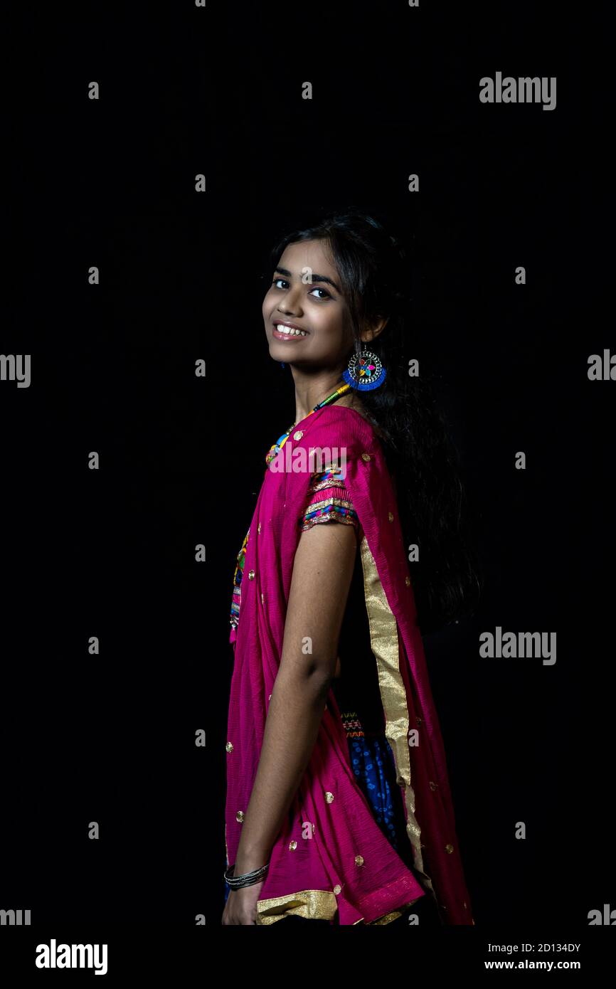 Indian girl in traditional chaniya choli for navratri with a fashionable  hairstyle poses in studio on black background. Navratri is an Indian  Festival Stock Photo - Alamy