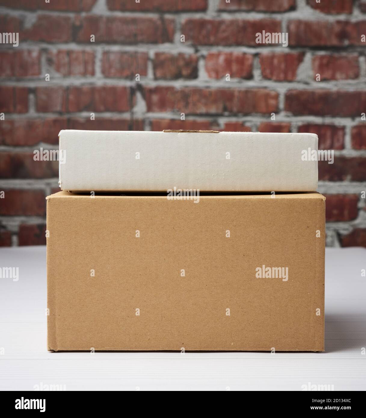rectangular box made of brown corrugated cardboard on a brown brick wall background, close up Stock Photo