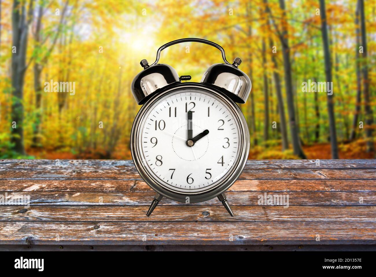Vintage clock in a forest in autumn. Fall daylight savings time change concept Stock Photo