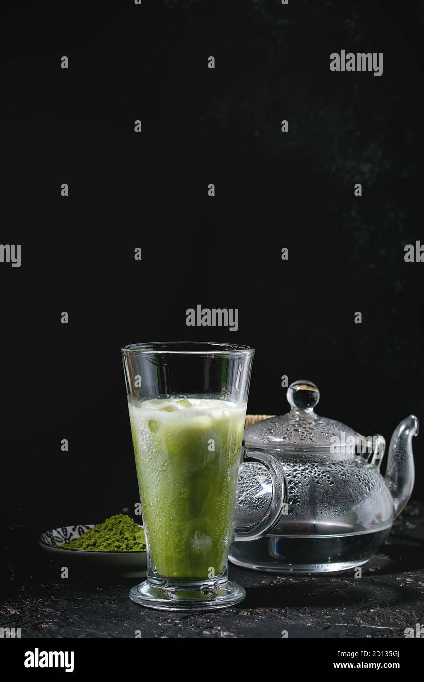 https://c8.alamy.com/comp/2D135GJ/matcha-green-tea-iced-latte-or-cocktail-in-tall-glass-with-ice-cubes-mint-matcha-powder-and-transparent-teapot-with-hot-water-over-dark-texture-back-2D135GJ.jpg