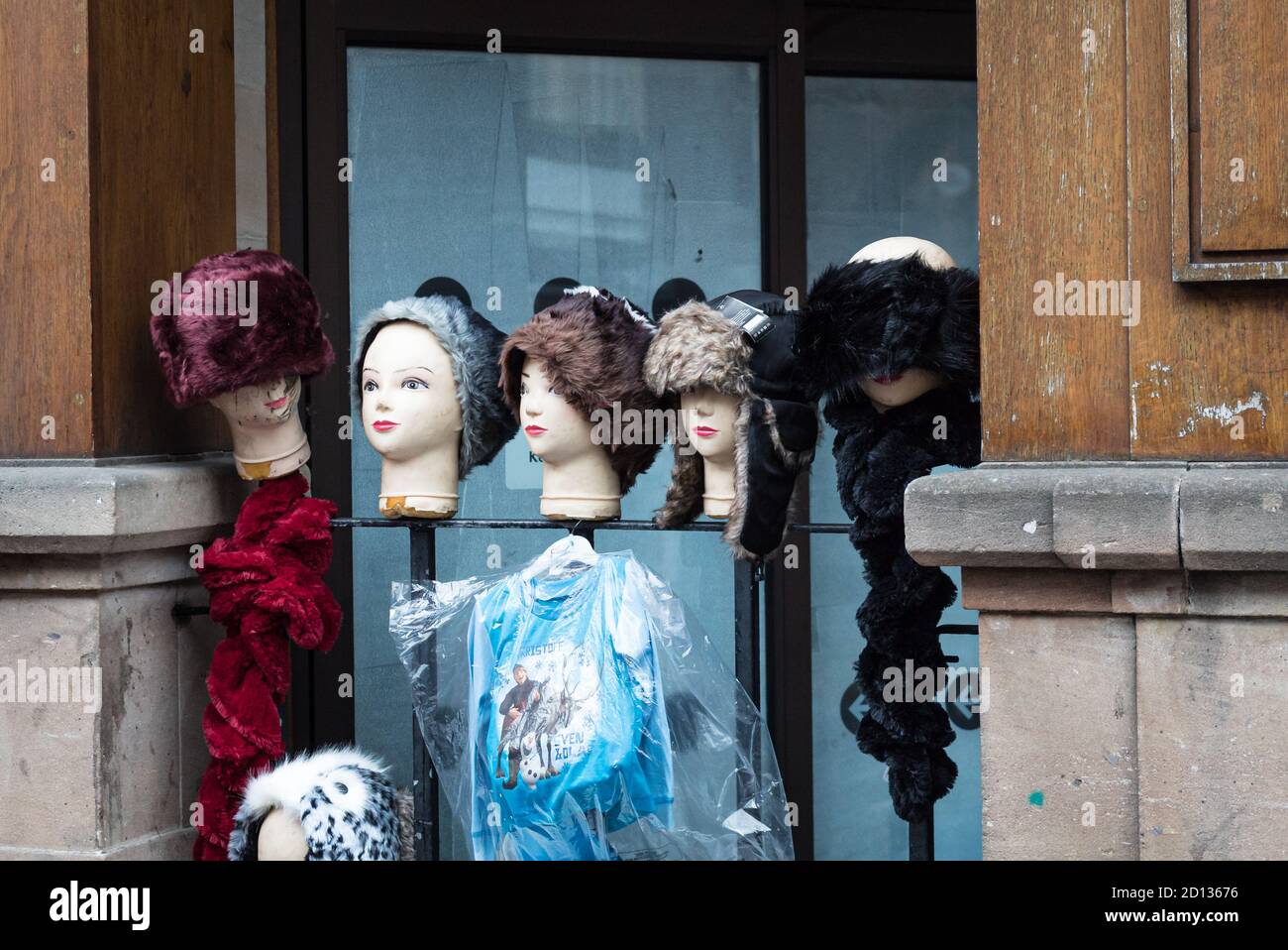 Hats on mannequin heads at a street stall on Chester's Eastgate Street shelter in a window alcove Stock Photo