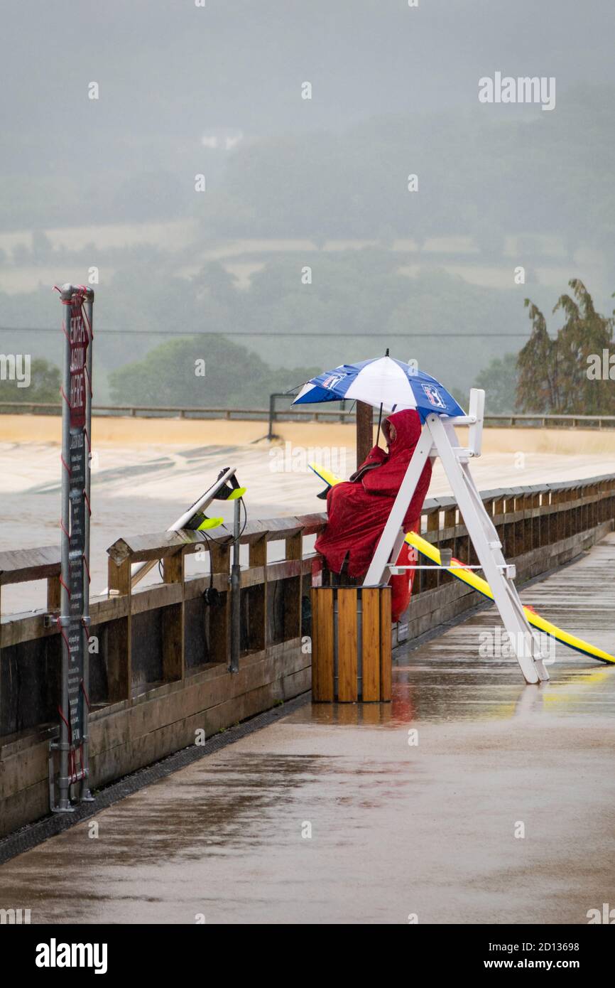 Lifeguard on duty at Surf Snowdonia, Wales despite the inclement weather. Stock Photo