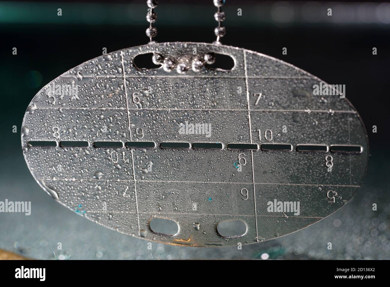 Closeup shot of dog tag of the German Bundeswehr with water drops Stock Photo