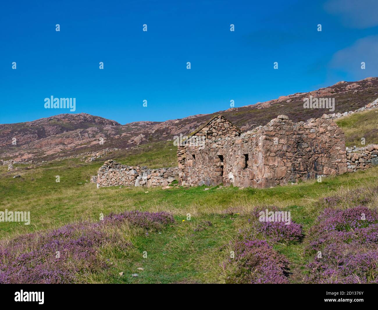 An abandoned, derelict farmhouse and out buildings near North Ham on Muckle Roe, Shetland, UK - taken on a sunny day with a clear sky in summer Stock Photo