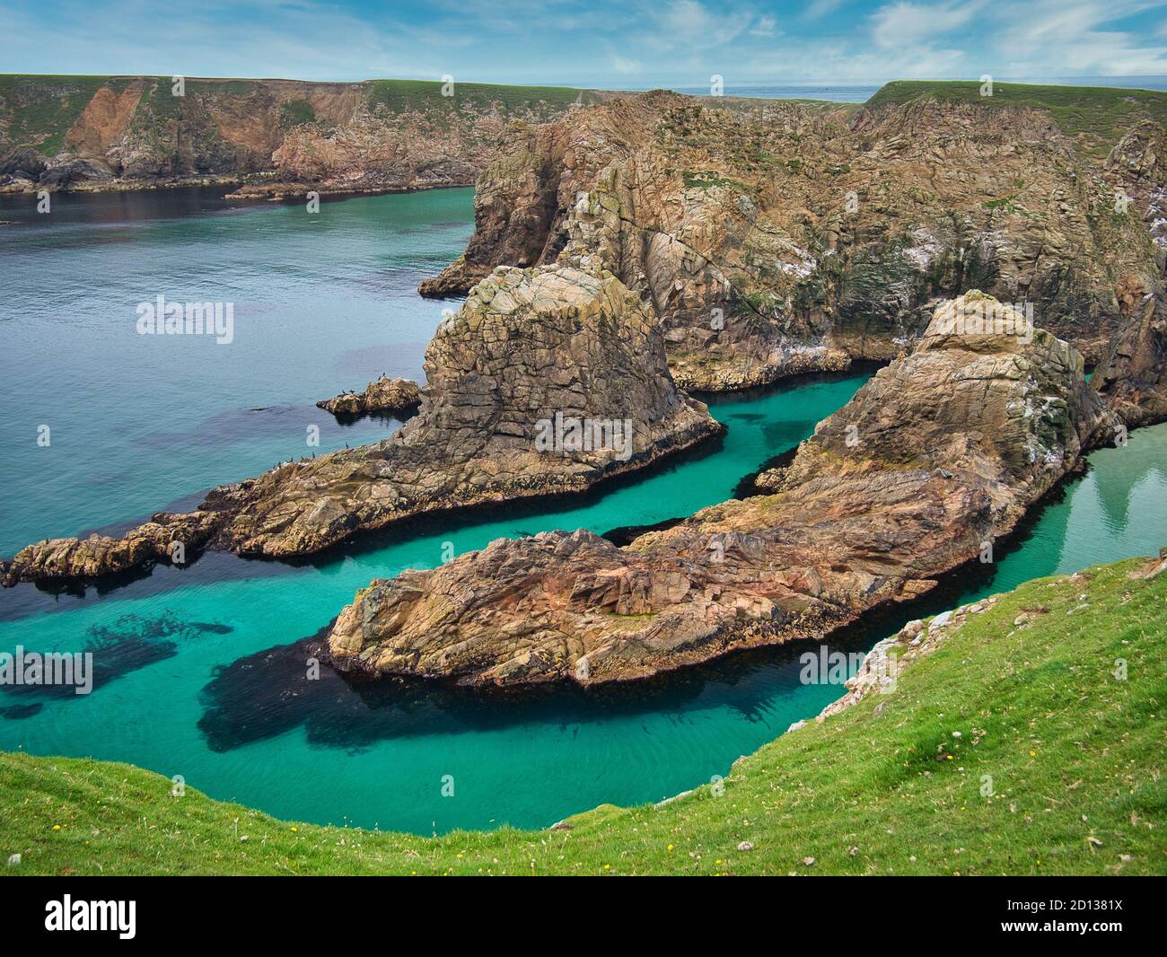 The clean, clear water and eroded coastline of north Shetland at the island of Uyea in north Mainland, Shetland, Scotland, UK - rocks are of the Uyea Stock Photo