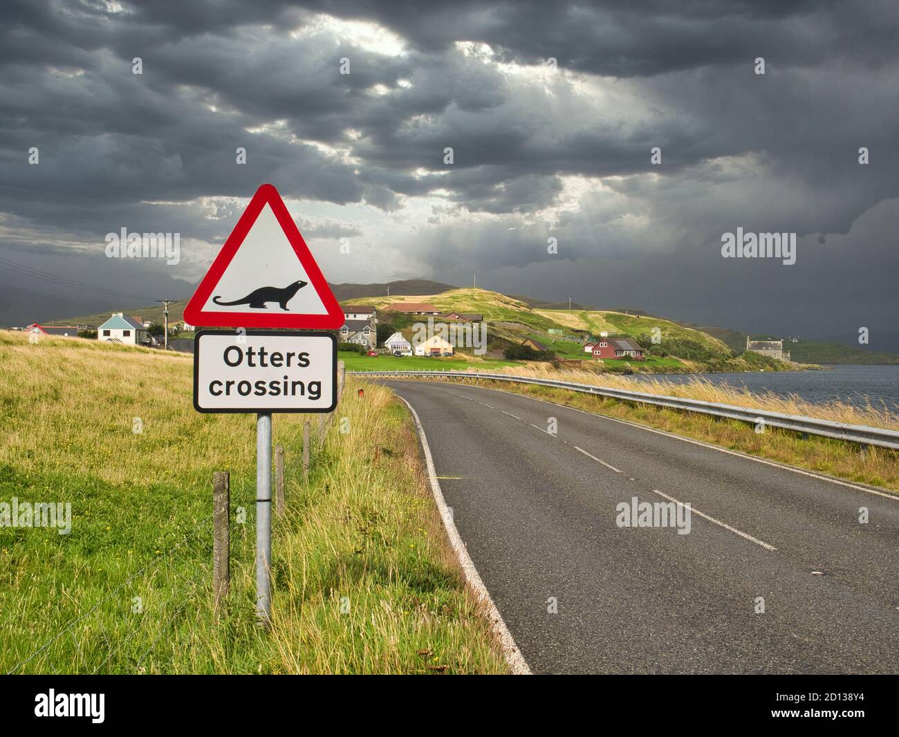 A sign warning motorists to watch for otters crossing the road near Whiteness in Shetland, Scotland, UK - the Loch of Strom is on the right. Stock Photo