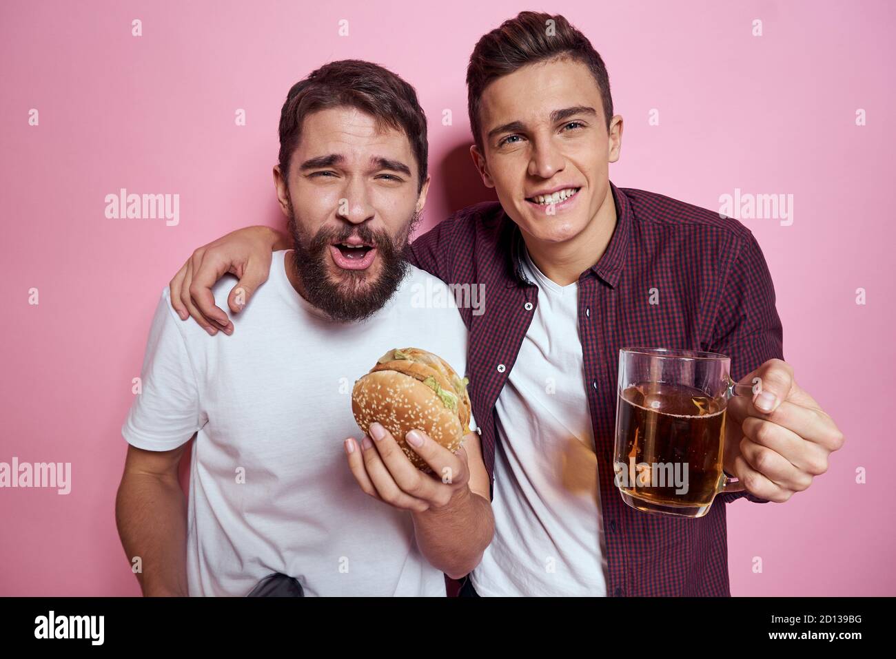 Two men drink beer friendship drunk alcohol lifestyle pink background Stock Photo Alamy