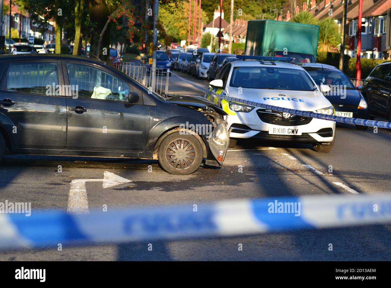Car crash inside police tape with police car guarding the cordon, West Midlands Police, Birmingham Stock Photo