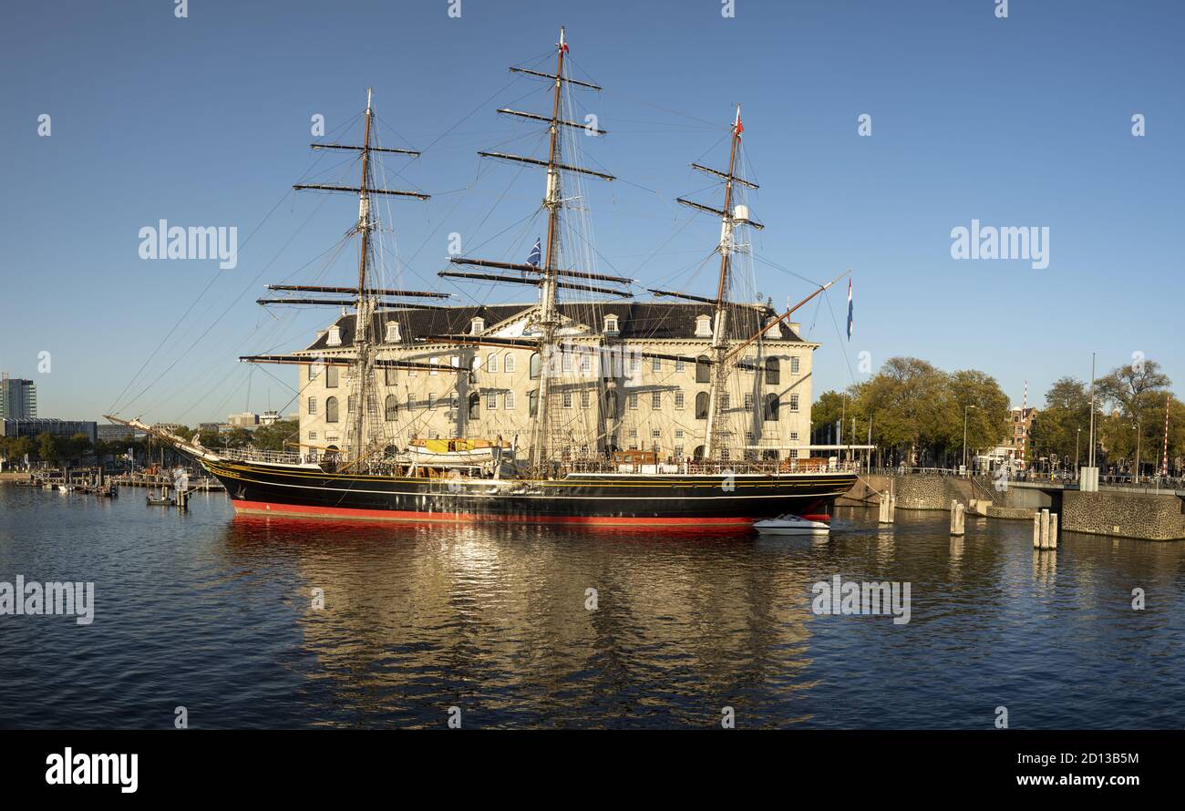 AMSTERDAM, NETHERLANDS - Sep 22, 2020: Historic seafarer sail ship in front of open air maritime Scheepvaart museum against a clear blue sky Stock Photo
