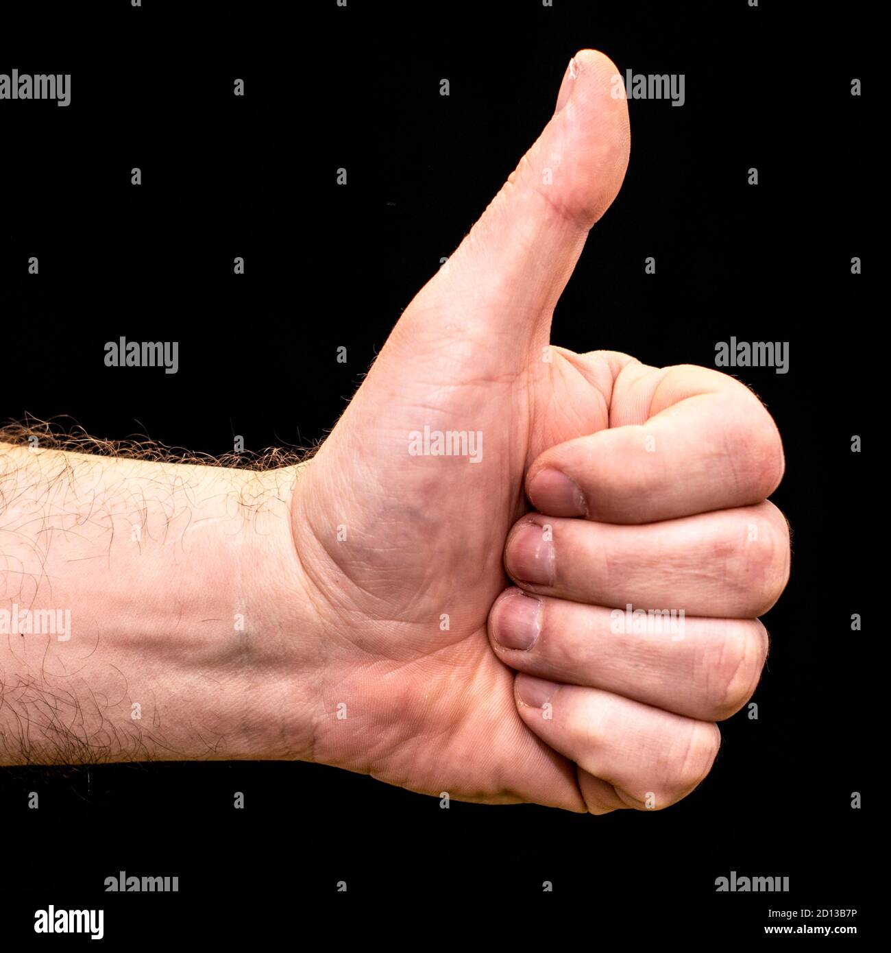 man's hand clenched into a fist with thumb up on a black background
