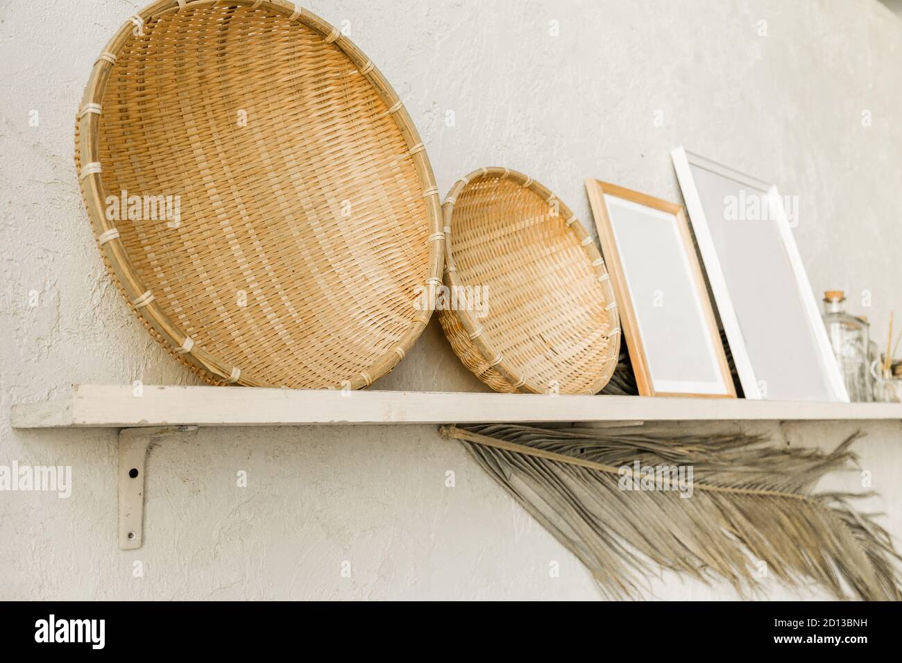 Decorative wooden plates and photo frames stand on the shelf Stock Photo