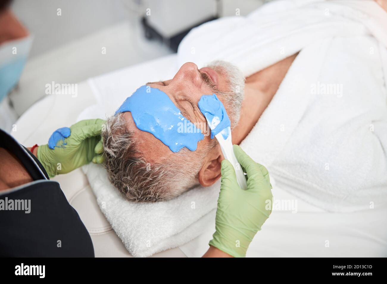 Aging male client of a spa salon enjoying a face mask Stock Photo