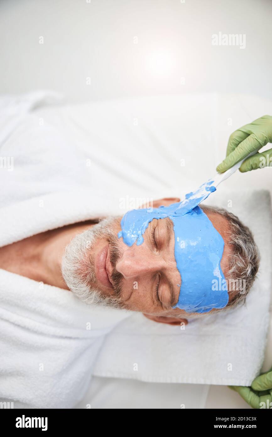 Aging man having facial treatment at a beauty salon Stock Photo