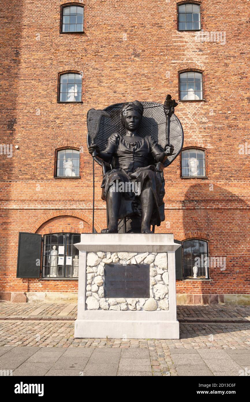 statue of Mary Thomas alias Queen Mary next to brick building 'Westindian storehouse', Copenhagen, Denmark Stock Photo