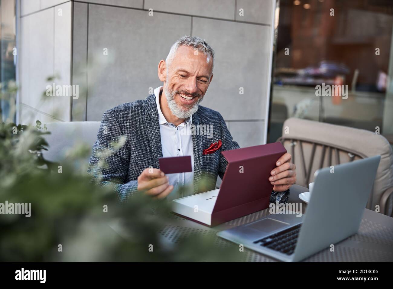 Gladsome senior man holding a plastic card Stock Photo