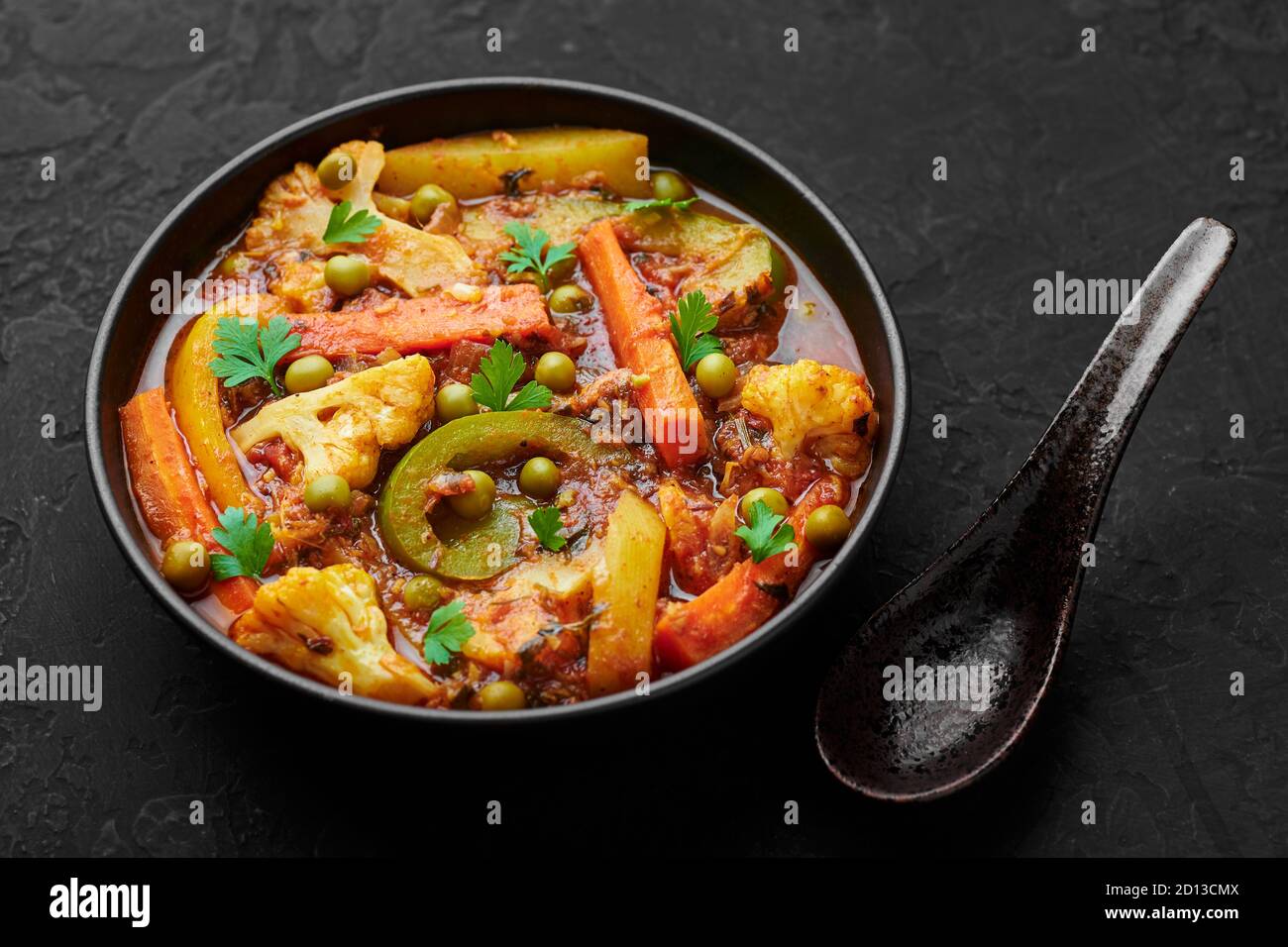 Veg Kolhapuri in black bowl on dark slate table top. Indian vegetable