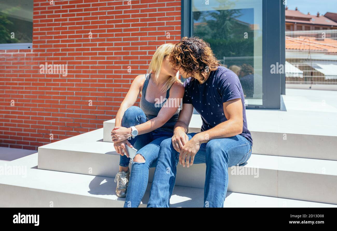 Couple kissing in front new house Stock Photo Alamy