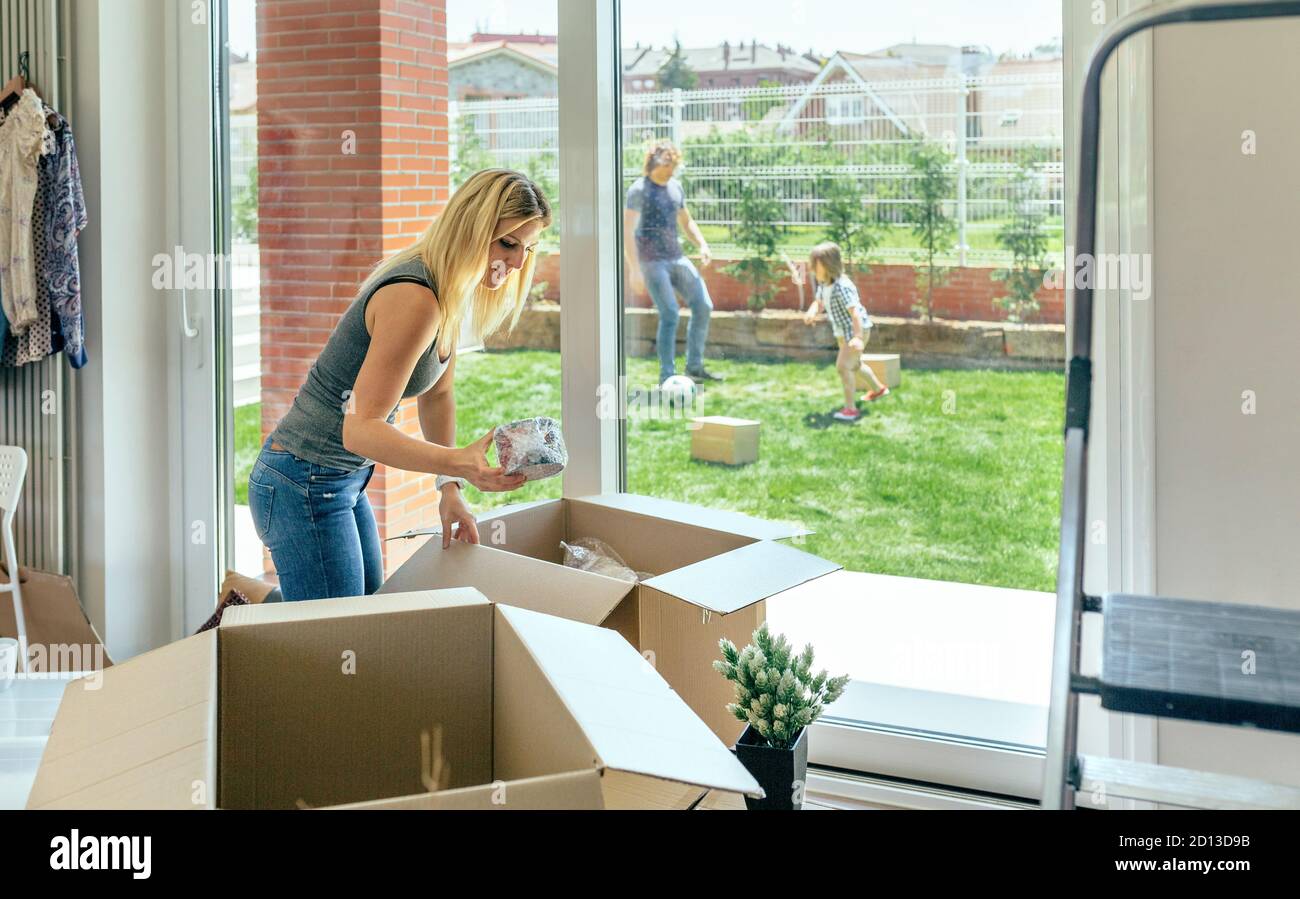 Woman unpacking moving boxes Stock Photo