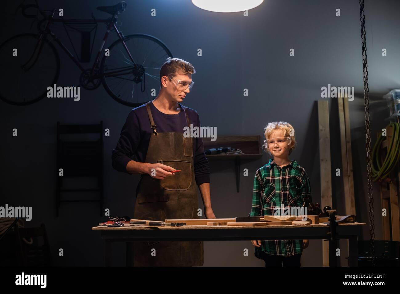 an experienced carpenter and his young apprentice make wood crafts in ...