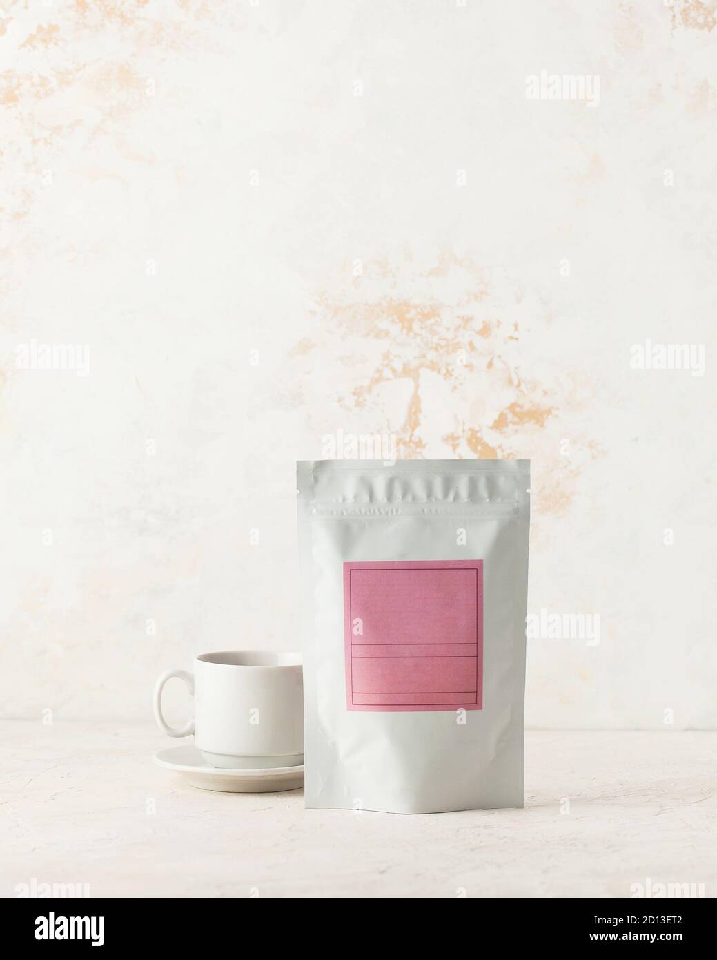 Aluminum bag for tea, coffee, seasonings and other bulk substances with pink label for signature on a light background. Stock Photo